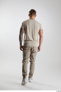 Gilbert 1 back view dressed grey t-shirt grey trousers walking…